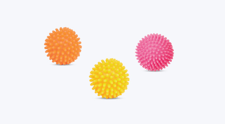 Zabawki dla psa: żółta, różowa i pomarańczowa piłka z kolcami.