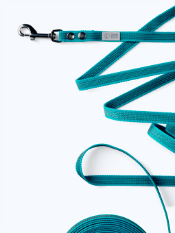 Zbliżenie na sprzączkę i zwiniętą smycz treningową niebieską 8m marki John Dog.