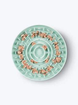 Zielona, okrągła mata do lizania dla psa marki Trixie z jedzeniem.