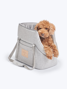 Pies rasy pudel toy będący w jasno-szarej torbie dla psa, marki John Dog.