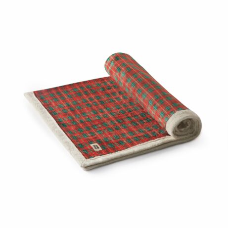 Świąteczny koc dla psa, zwinięty w rulon, pokazujący praktyczność i możliwość łatwego przechowywania.