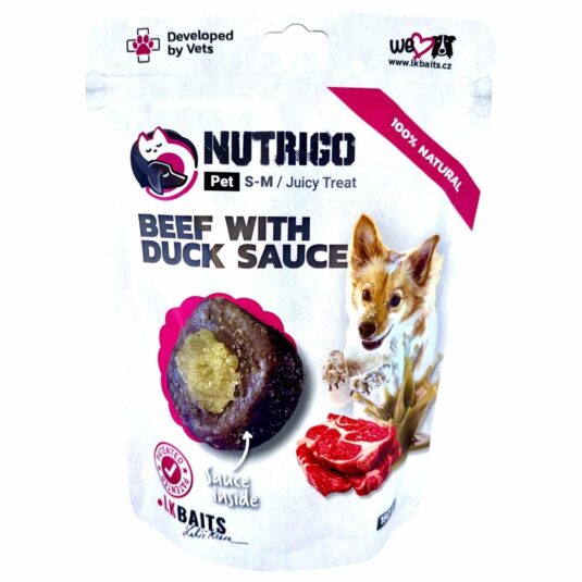 Przysmak Nutrigo dla psów, zawierający cielęcinę z dodatkiem sosu z kaczki. Przysmak o ciemnobrązowej strukturze, z widocznym, kremowym wnętrzem.