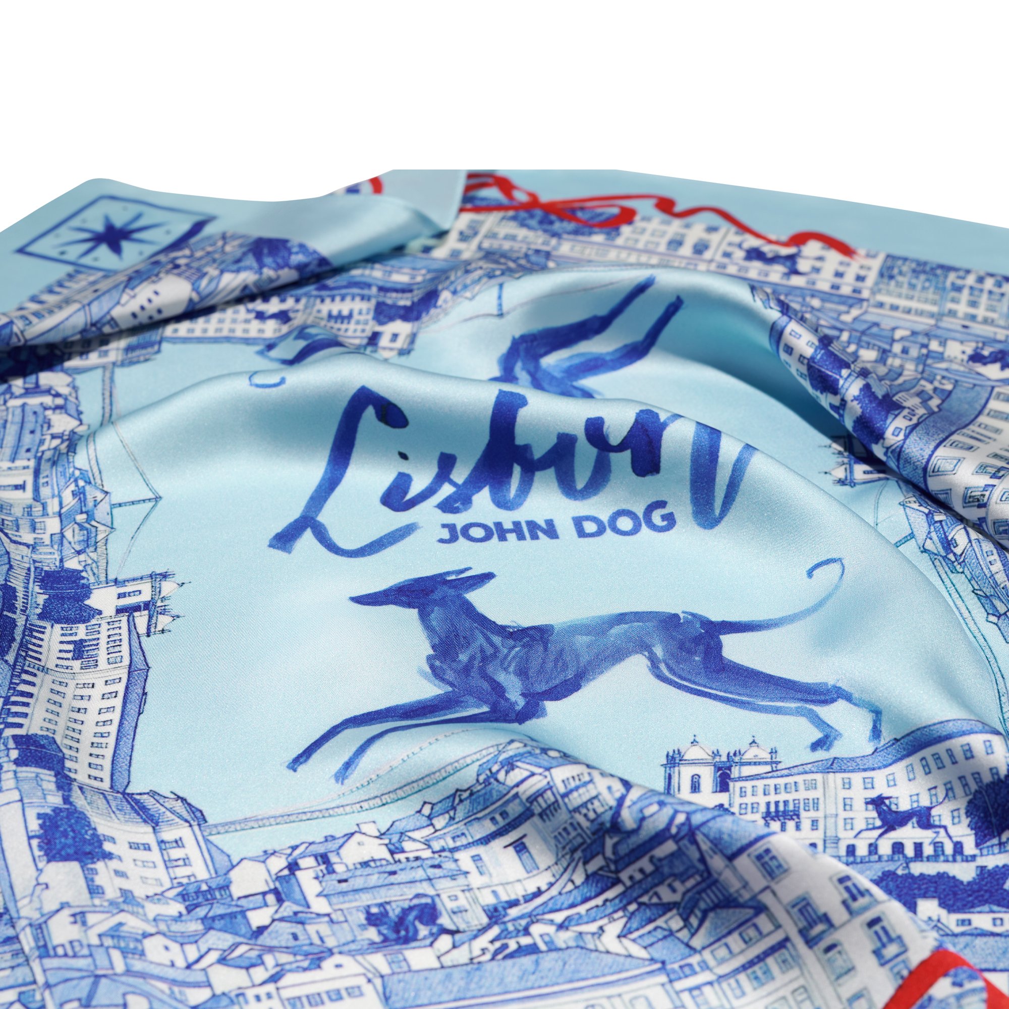Zbliżenie na apaszkę John Dog z kolekcji Lizbona w kolorze błękitnym przedstawiające rysunek granatowego psa rasy chart otoczone rysunkiem granatowych kamienic.