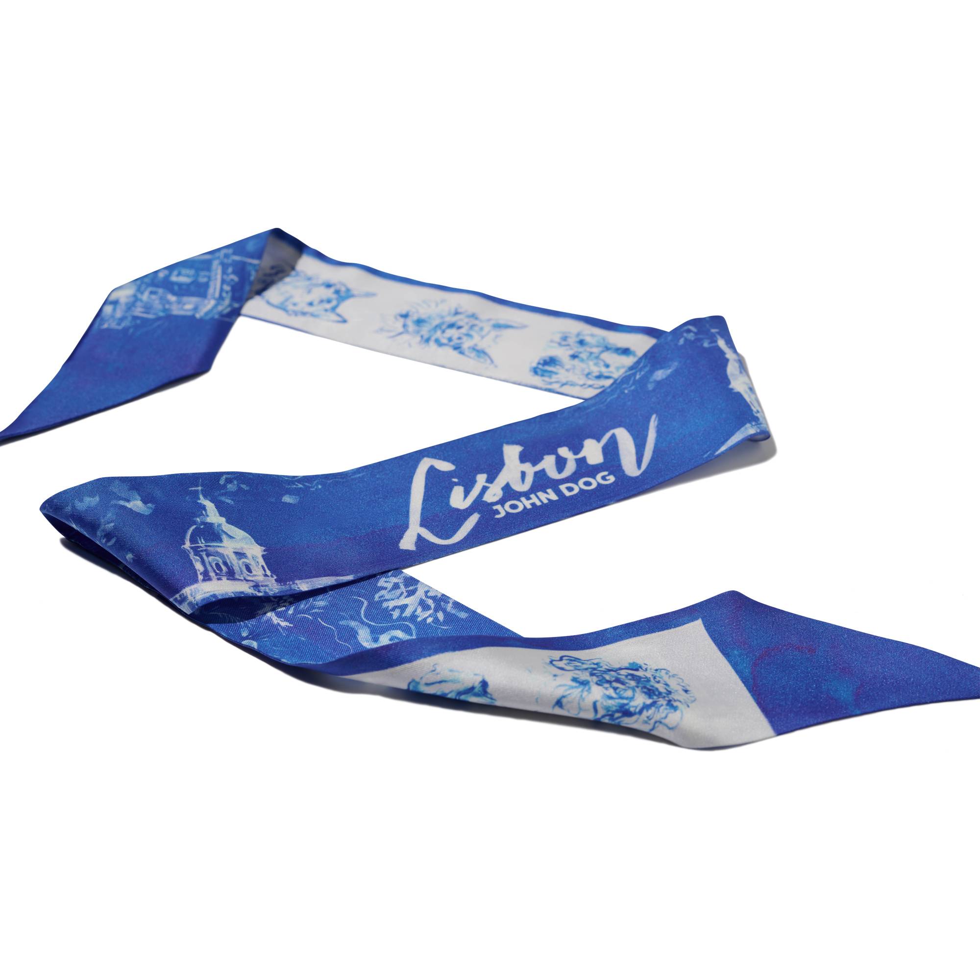Cienka, dwustronna apaszka John Dog z kolekcji Lizbona w kolorze biało-granatowym ułożona na kształt litery Z. Z jednej strony są na niej rysunki granatowych portretów psów różnych ras na białym tle, a z drugiej rysunek białej panoramy miasta na granatowym tle i napis Lisbon.