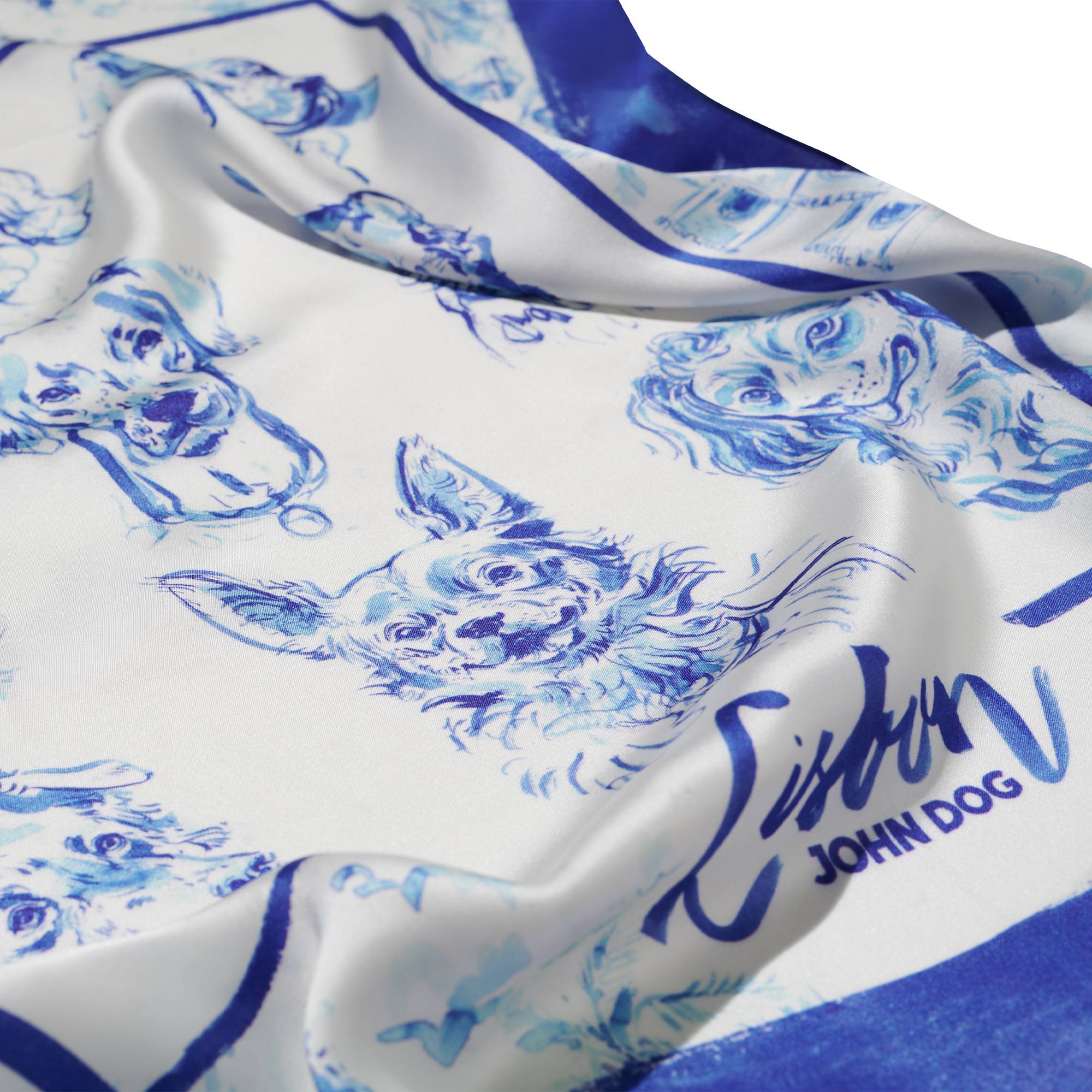 Zbliżenie na apaszkę John Dog z kolekcji Lizbona w kolorze biało-granatowym przedstawiająca rysunki portretów psów różnych ras z granatową obwódką. Na dole jest napis Lisbon, apaszka jest rozłożona na płasko z kilkoma marszczeniami.