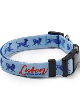 Błękitna obroża John Dog z kolekcji Lizbona we wzór z granatowymi psami i czerwonym napisem Lisbon po wewnętrznej stronie, zapięta czarną klamrą ułożona w owal.