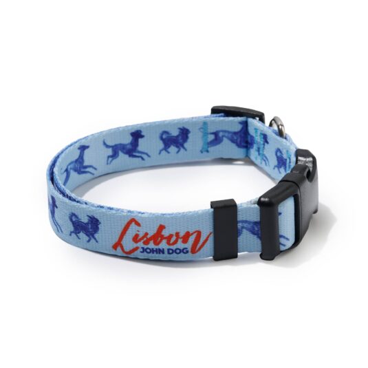 Błękitna obroża John Dog z kolekcji Lizbona we wzór z granatowymi psami i czerwonym napisem Lisbon po wewnętrznej stronie, zapięta czarną klamrą ułożona w owal.