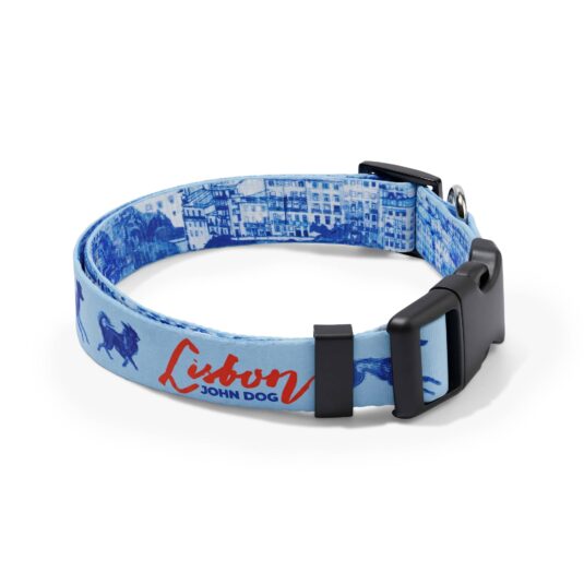 Błękitna obroża John Dog z kolekcji Lizbona we wzór z granatowymi psami i czerwonym napisem Lisbon po zewnętrznej stronie oraz rysunkiem panoramy miasta po wewnętrznej stronie, zapięta czarną klamrą ułożona w owal.