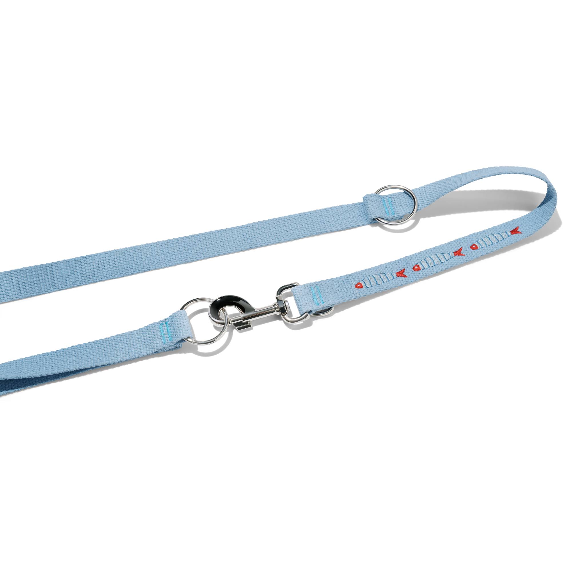 Zbliżenie na zapięcie smyczy przepinanej John Dog z kolekcji Lizbona w błękitnym kolorze z trzema haftami w kształcie rybek. Smycz jest zakrzywiona w łuk.