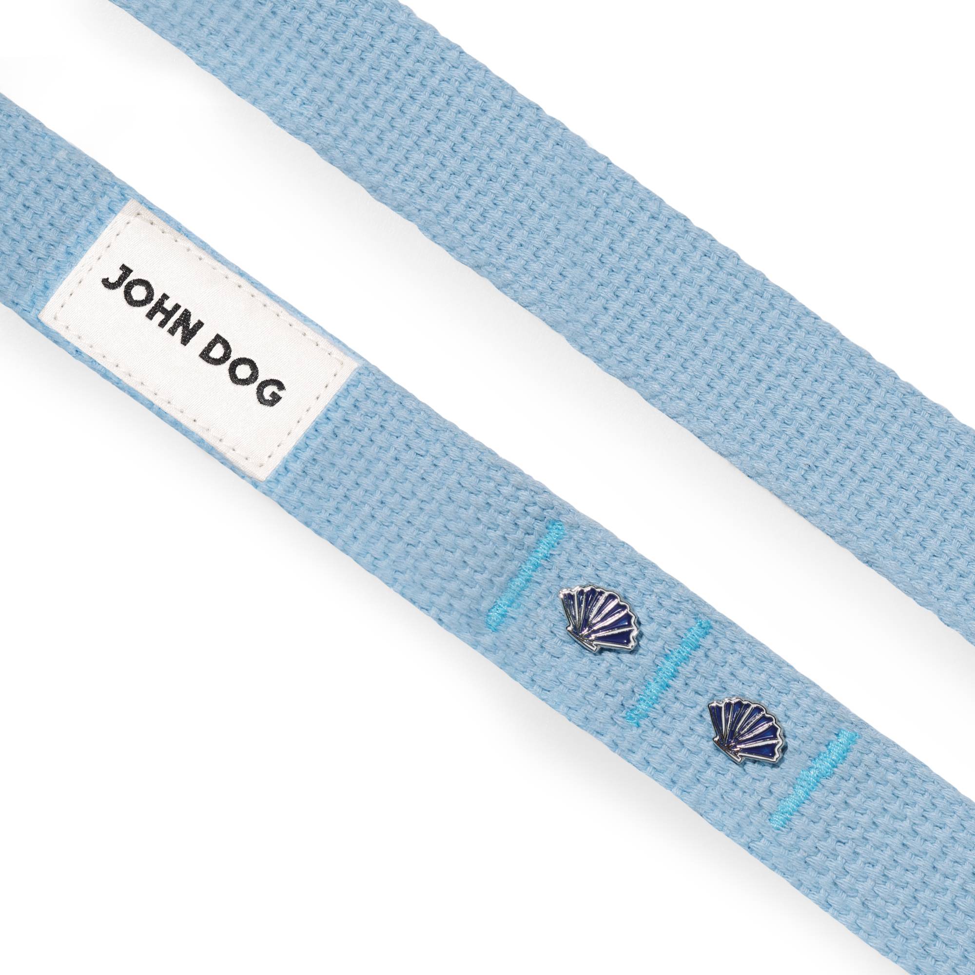 Zbliżenie na dwie taśmy smyczy przepinanej John Dog z kolekcji Lizbona w kolorze błękitnym z dwoma pinami w kształcie muszelki i beżowym logo.