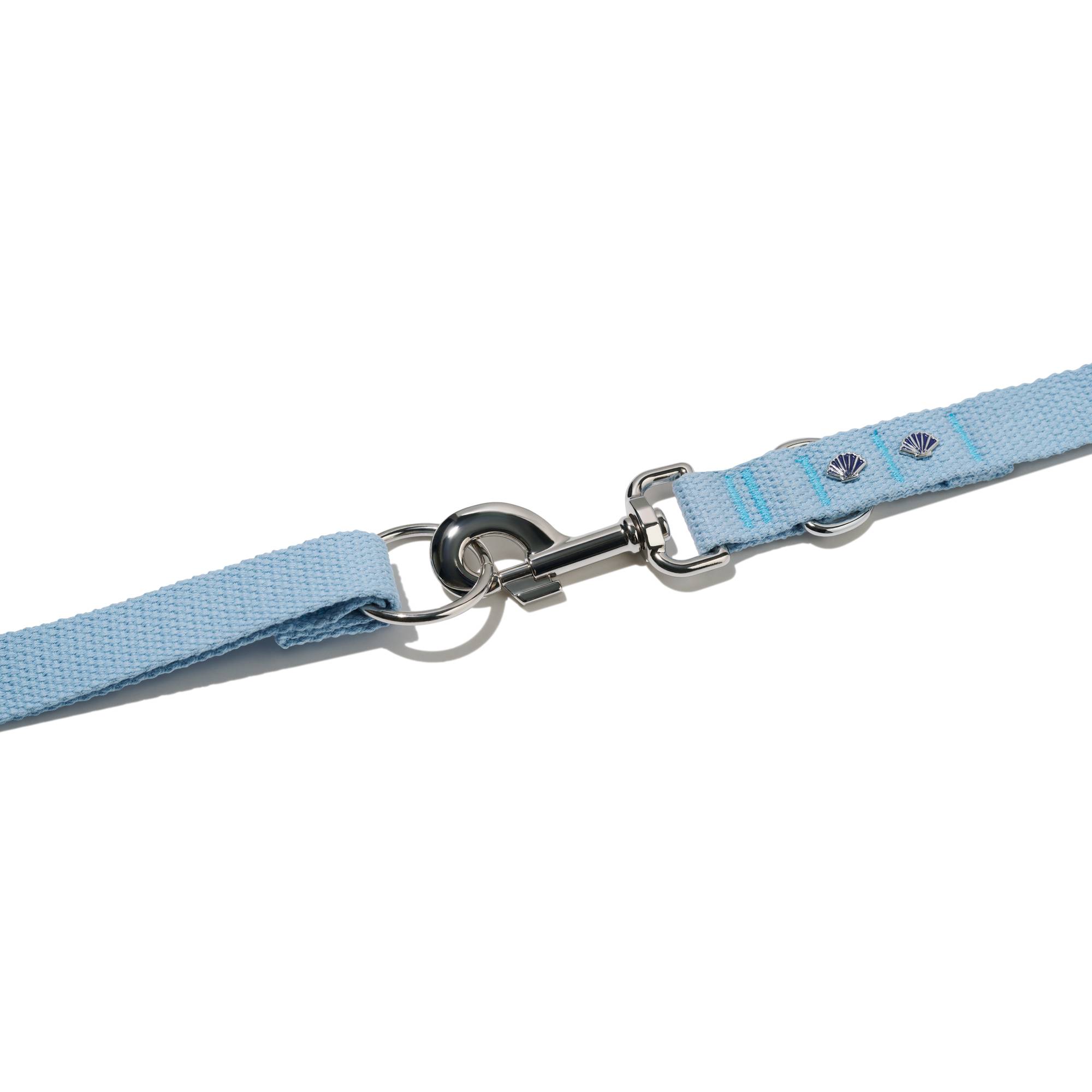 Zbliżenie na zapięcie błękitnej smyczy przepinanej John Dog z kolekcji Lizbona z dwoma pinami w kształcie muszelki.