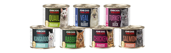 Karma mokra dla kota, musy John Dog. Puszki o pojemności 200g są ustawione w piramidę w dwóch rzędach. Na etykietach widnieją zdjęcia oblizujących się kotów różnych ras.