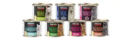 Karma mokra dla kota, musy John Dog. Puszki o pojemności 200g są ustawione w piramidę w dwóch rzędach. Na etykietach widnieją zdjęcia oblizujących się kotów różnych ras.
