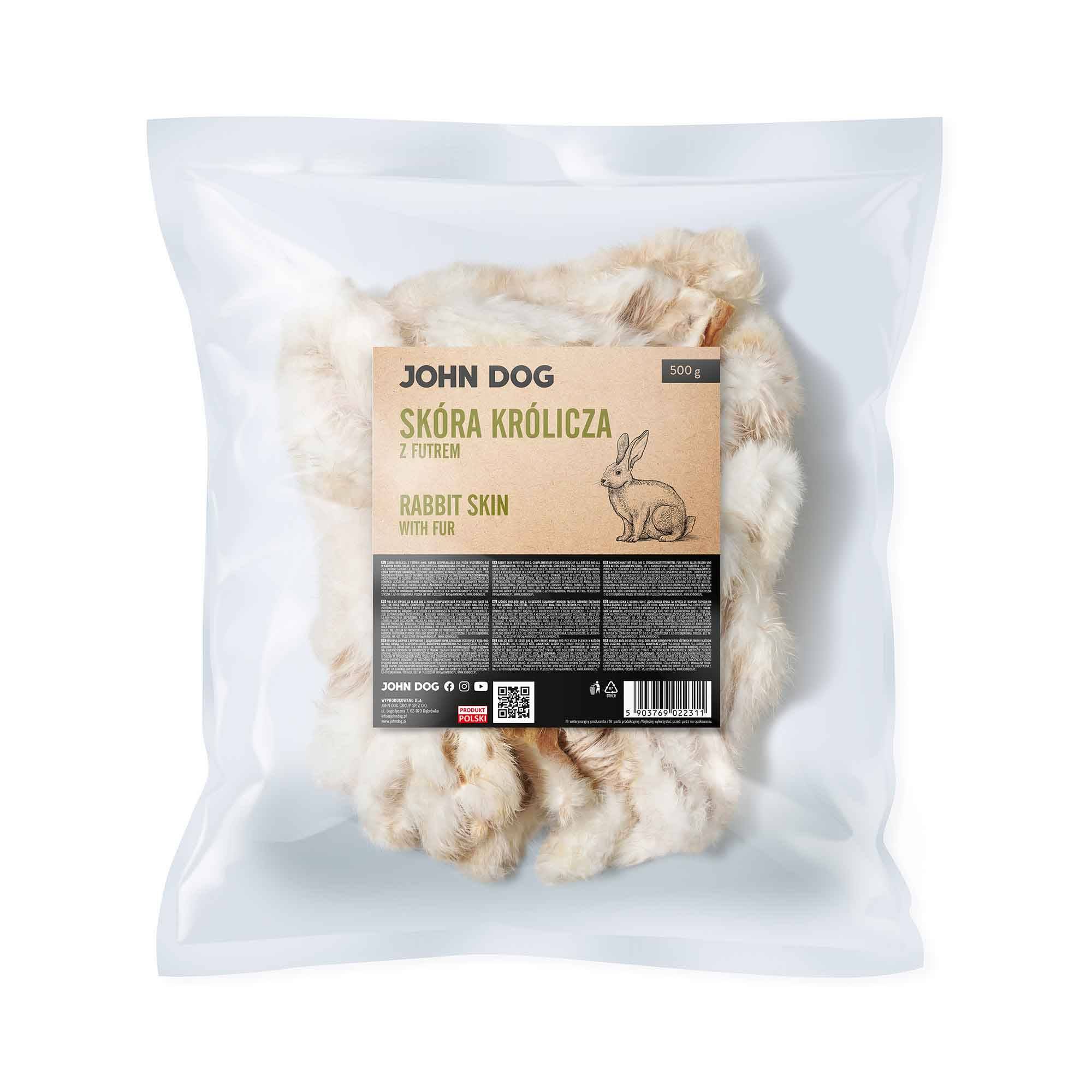 Transparentne opakowanie gryzaków naturalnych dla psa marki John Dog z beżowo-czarną etykietą. Na etykiecie napis „Skóra królicza z futrem/Rabbit skin with fur 500 g” ilustracja królika, opis gryzaków, kod qr i kod kreskowy . W środku widoczne suszone kawałki skóry króliczej z futrem.