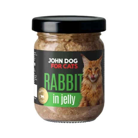Słoik mokrej karmy z czarnym wieczkiem dla kotów John Dog for Cats o smaku królika, w galaretce. Na ciemnej etykiecie widoczny jest rudy puszysty kot i zielone napisy.