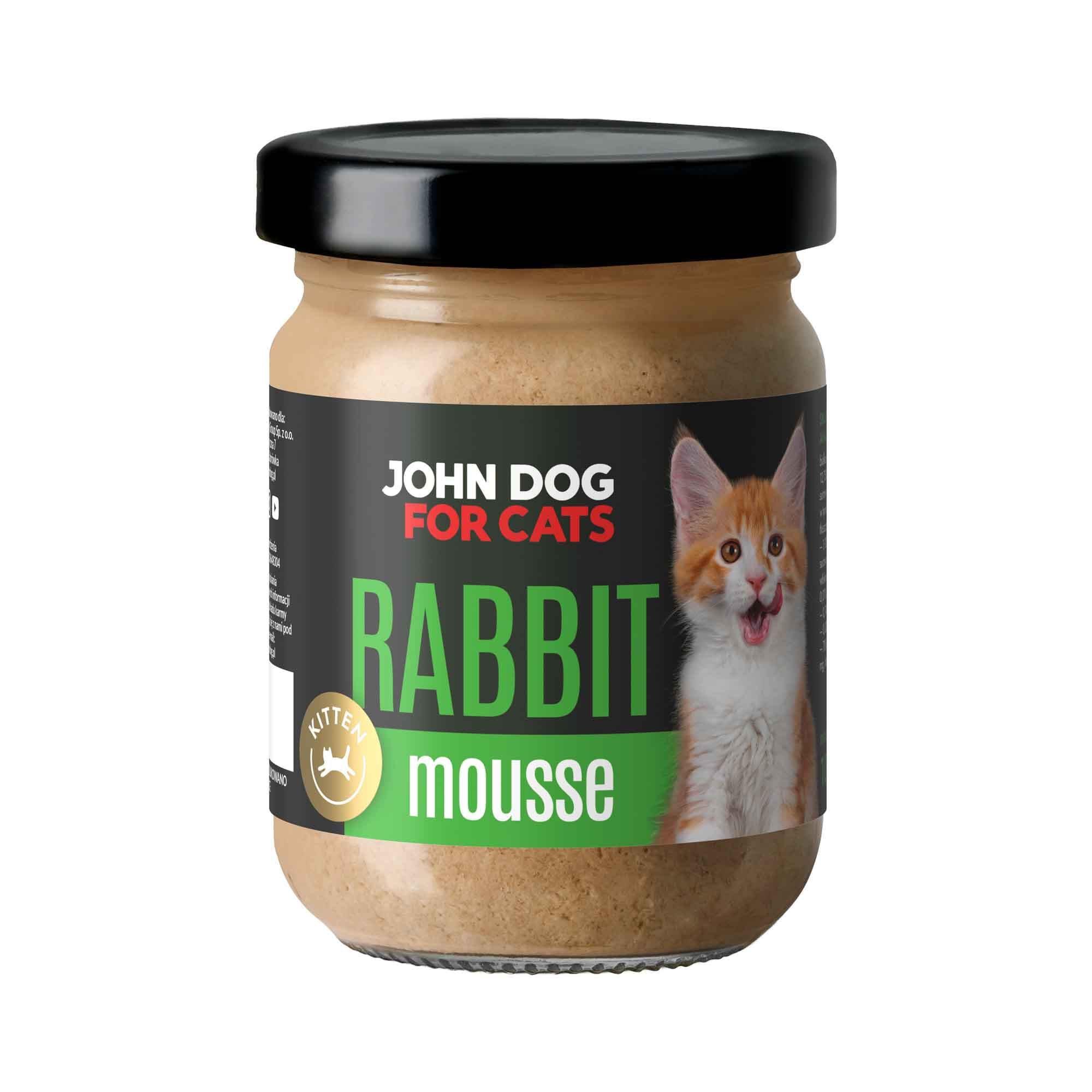 Słoik mokrej karmy z czarnym wieczkiem dla kociąt John Dog for Cats o smaku królika, w musie. Na ciemnej etykiecie widoczny jest biało rudy kociak i zielone napisy.