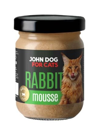 Słoik mokrej karmy z czarnym wieczkiem dla kotów John Dog for Cats o smaku królika, w musie. Na ciemnej etykiecie widoczny jest rudy puszysty kot i zielone napisy.