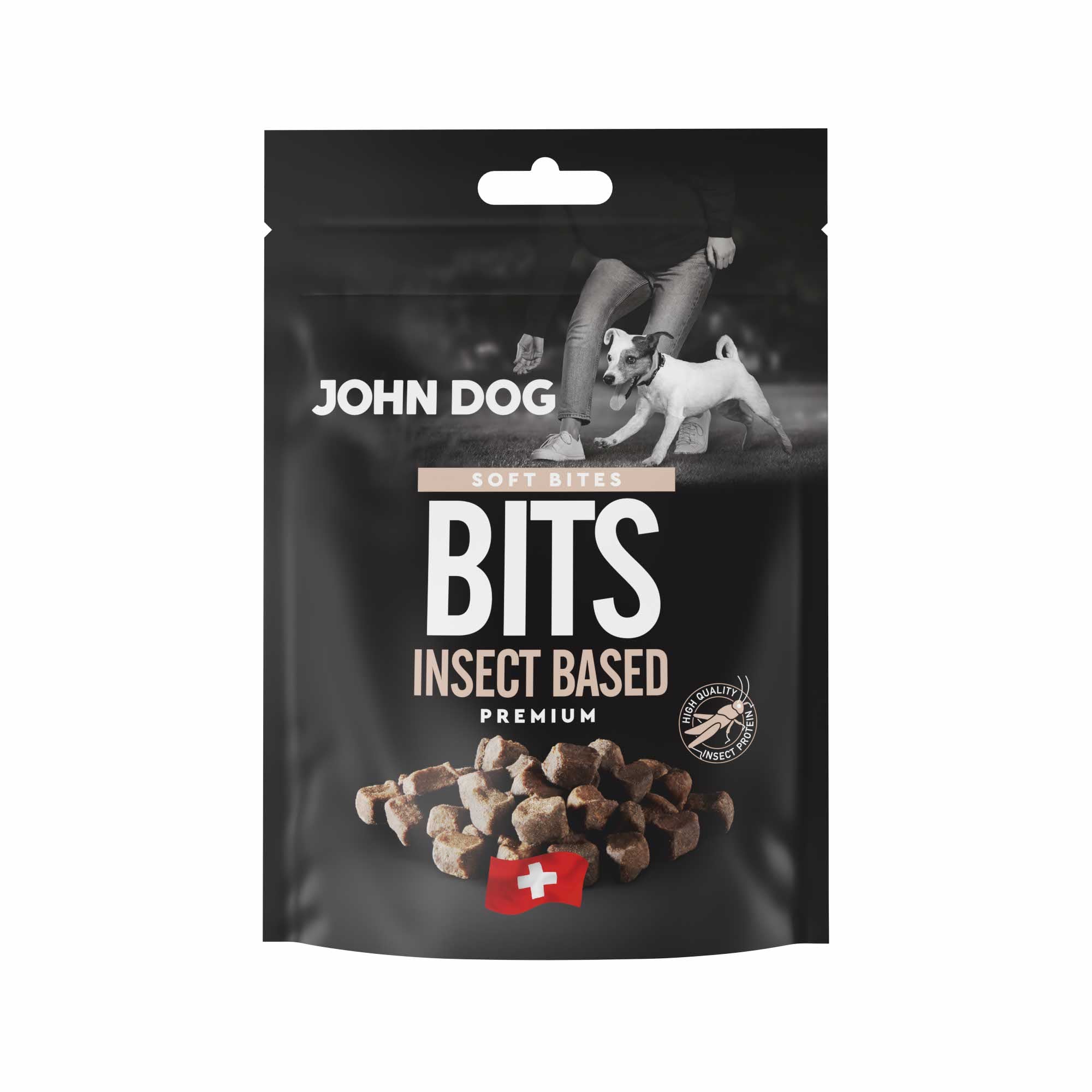 Czarne opakowanie przysmaków dla psów John Dog Bits Insect Base Chews Premium. Na opakowaniu znajduje się zdjęcie psa obok człowieka, grafika przysmaków w kształcie kosteczek oraz symbol szwajcarskiej flagi.
