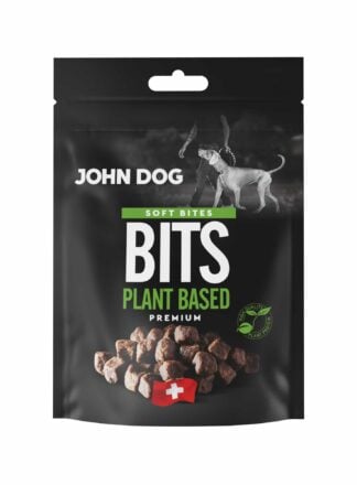 Czarne opakowanie przysmaków dla psów John Dog Bits Soft Bites Premium-kawałki zawierające produkty pochodzenia roślinnego. Na opakowaniu znajduje się zdjęcie psa obok człowieka, grafika suszonych kostek oraz symbol szwajcarskiej flagi.