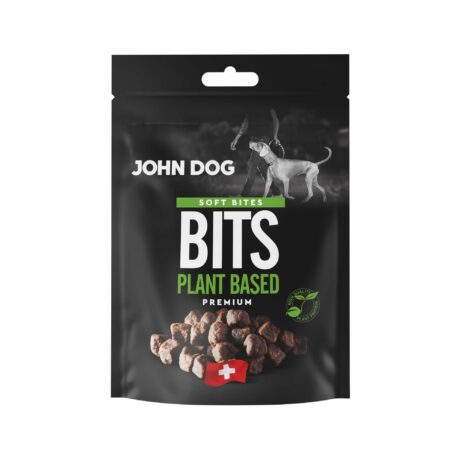 Czarne opakowanie przysmaków dla psów John Dog Bits Soft Bites Premium-kawałki zawierające produkty pochodzenia roślinnego. Na opakowaniu znajduje się zdjęcie psa obok człowieka, grafika suszonych kostek oraz symbol szwajcarskiej flagi.
