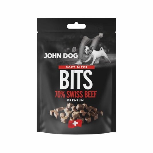 Czarne opakowanie przysmaków dla psów John Dog Bits Soft Bites Premium-kawałki zawierające 70% mięsa z wołowiny. Na opakowaniu znajduje się zdjęcie psa obok człowieka, grafika suszonych kostek mięsa oraz symbol szwajcarskiej flagi.