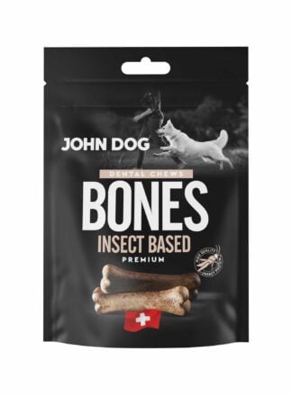 Czarne opakowanie przysmaków dla psów John Dog Bones Dental Chews Premium. Na opakowaniu znajduje się zdjęcie psa obok człowieka, grafika przysmaków w kształcie kości oraz symbol szwajcarskiej flagi.