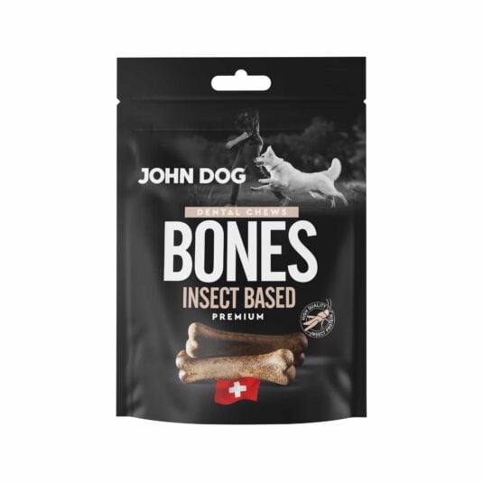 Czarne opakowanie przysmaków dla psów John Dog Bones Dental Chews Premium. Na opakowaniu znajduje się zdjęcie psa obok człowieka, grafika przysmaków w kształcie kości oraz symbol szwajcarskiej flagi.