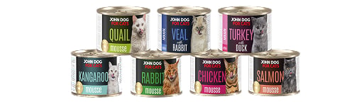 Siedem małych puszek mokrej karmy dla kotów John Dog Mousse. Puszki są ustawione w dwóch rzędach, na etykietach są wizerunki kotów różnych ras.