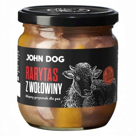 Mały słoik rarytasów John Dog z czarnym wieczkiem i czarną etykietą. Na etykiecie ilustracja krowy. W słoiku widać kawałki mięsa.