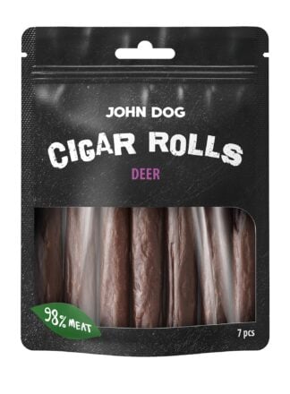Przysmaki dla psa, siedem paluchów z jelenia John Dog w czarnym opakowaniu z transparentną folią na środku przez którą widać produkt. Paluchy są w kolorze brązowym, na etykiecie jest umieszczony zielony listek z białym napisem, widok z przodu.